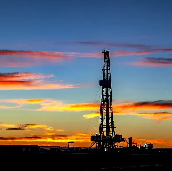 oil rig drilling at sunset